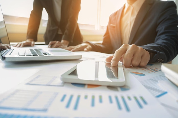 Des hommes d'affaires discutant de graphiques à leur bureau.