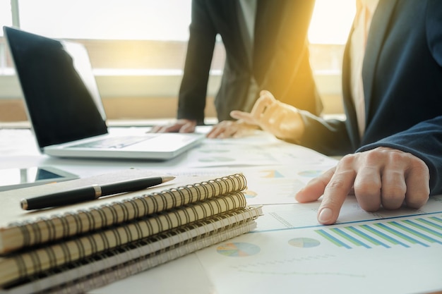 Des hommes d'affaires discutant de graphiques à leur bureau.