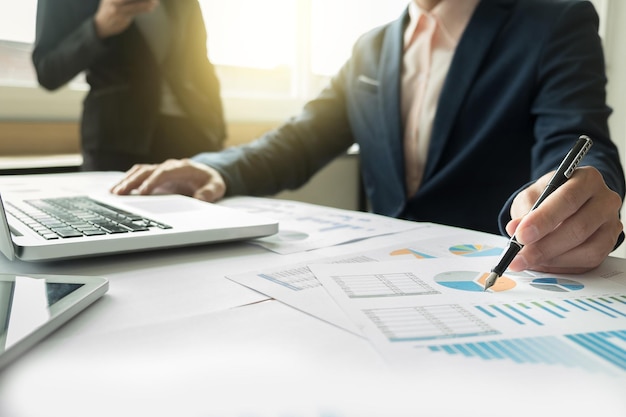 Des hommes d'affaires discutant de graphiques à leur bureau.