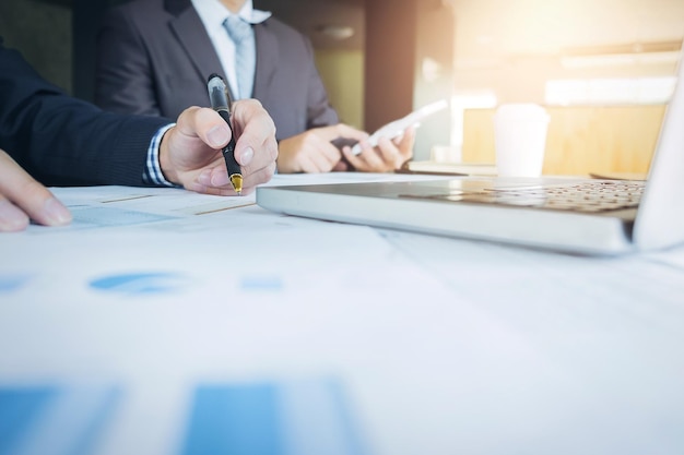 Des hommes d'affaires discutant de graphiques à leur bureau.