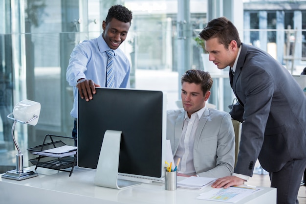 Hommes d'affaires discutant à table sur ordinateur