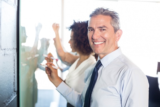 hommes d&#39;affaires écrit sur un tableau blanc au bureau