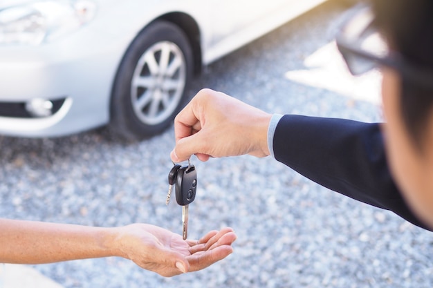 Les hommes d&#39;affaires envoient leurs clés de voiture aux nouveaux propriétaires.