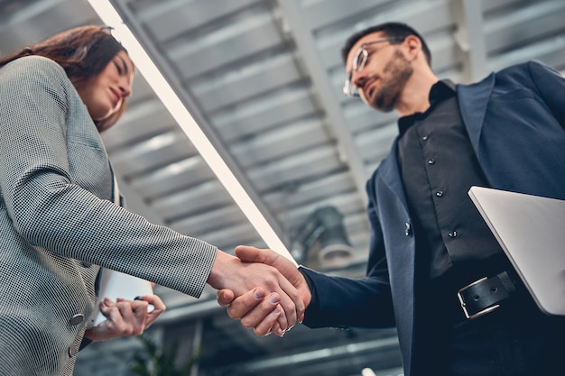 Des Hommes D'affaires Heureux Portant Une Robe De Costume Travaillant Au Bureau Du Loft Tout En Se Tenant La Main Ensemble