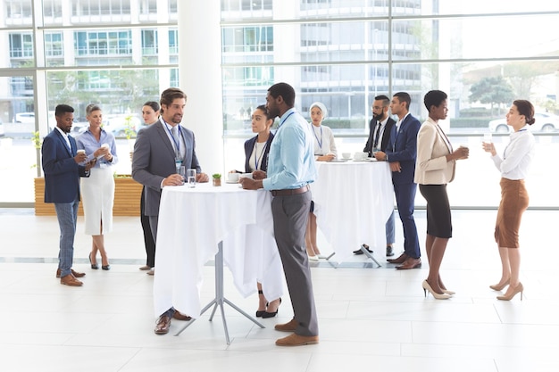 Photo des hommes d'affaires interagissant entre eux à table lors d'un séminaire