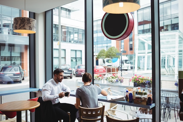 Hommes d'affaires interagissant tout en buvant un café