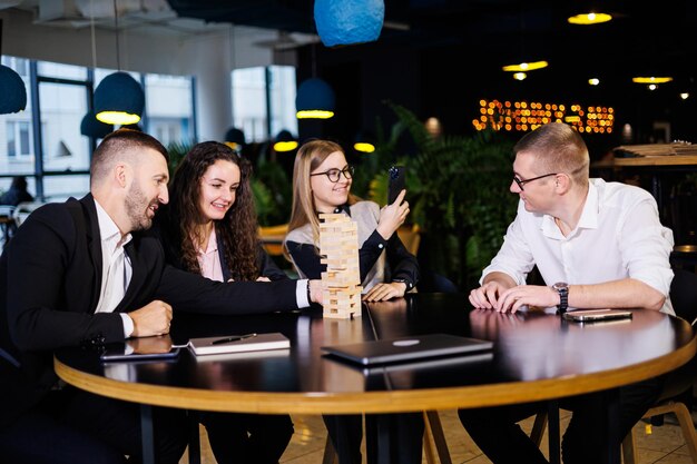 Les hommes d'affaires jouent au jenga Concept de vacances d'affaires Les jeunes jouent à des jeux de société au bureau