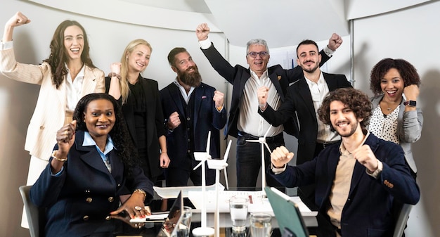 Des hommes d'affaires multiethniques joyeux regardant la caméra à l'intérieur du siège social pour une photo de groupe tout en travaillant ensemble sur un projet d'innovation durable Concept de réalisation des objectifs