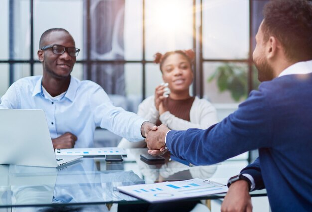 Des hommes d'affaires multiethniques ravis se serrent la main saluant faire connaissance au bureau