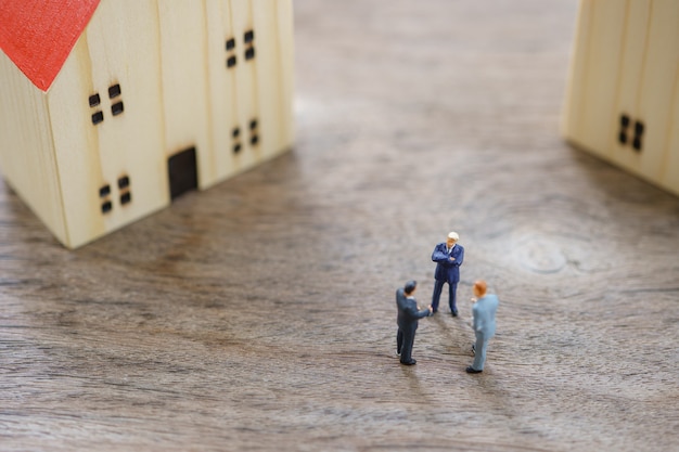 Photo hommes d'affaires de personnes miniatures debout pour vérifier la qualité dans la maison