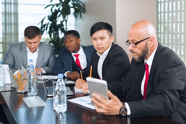 Hommes d'affaires réunis autour d'une table de conférence pour discuter de stratégie