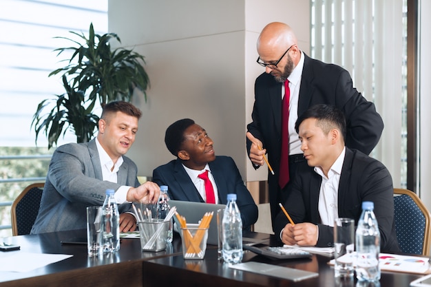 Hommes d'affaires réunis autour d'une table de conférence pour discuter de stratégie