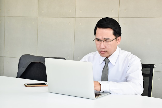 Photo les hommes d'affaires sont stressés par le dur labeur assis sur l'ordinateur avec le téléphone.