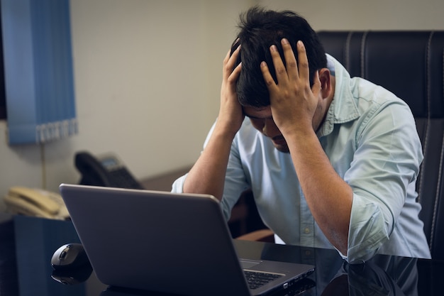 Les hommes d’affaires sont stressés par le dur labeur. Le mal de tête n&#39;est pas rafraîchi