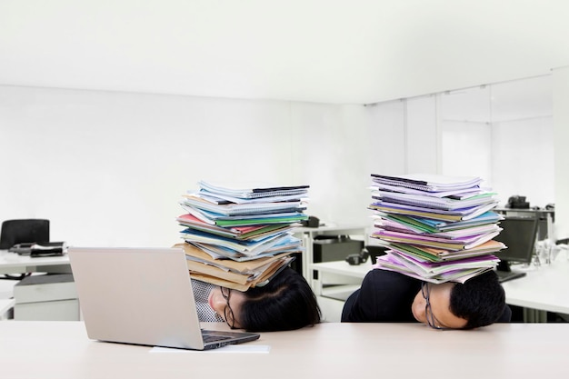 Les hommes d'affaires stressés dorment avec de la paperasse.