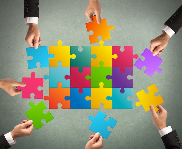 Hommes d'affaires travaillant ensemble pour construire un puzzle coloré