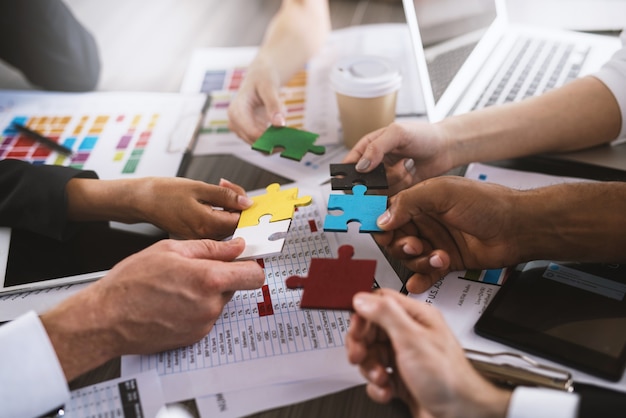 Hommes d'affaires travaillant ensemble pour construire un puzzle coloré