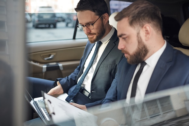 Hommes d'affaires travaillant pendant la conduite