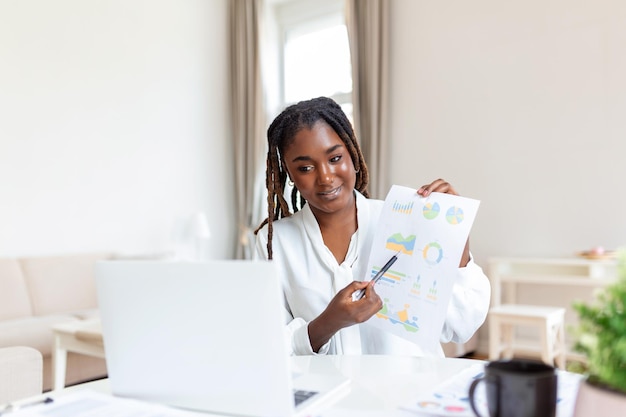 Les hommes d'affaires en vêtements décontractés travaillent au bureau sur la comptabilité et l'analyse du plan d'affaires Jeune femme noire à son bureau dans un bureau Graphiques et graphiques