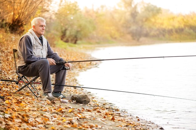 Hommes âgés pêchant au bord du lac.