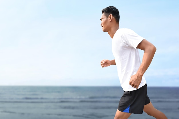 Des hommes asiatiques courent sur la plage.