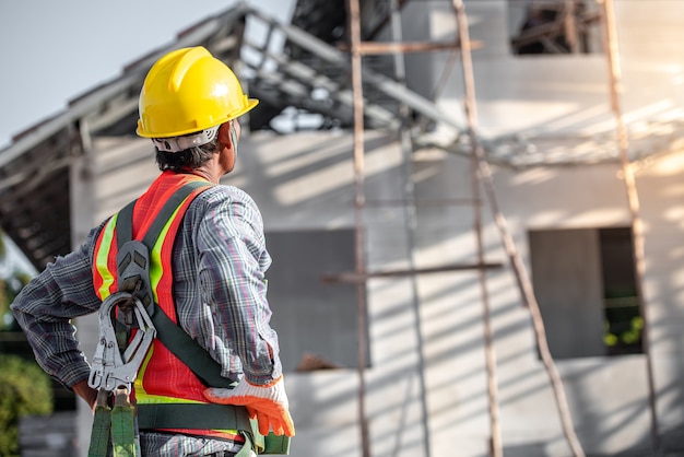 Hommes asiatiques portant des vêtements de sécurité casques de travailleur de la construction et gilets réfléchissants sur les chantiers de construction