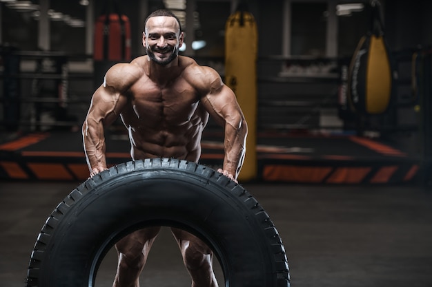 Hommes athlétiques bodybuilder forts brutaux pompant les muscles avec des haltères