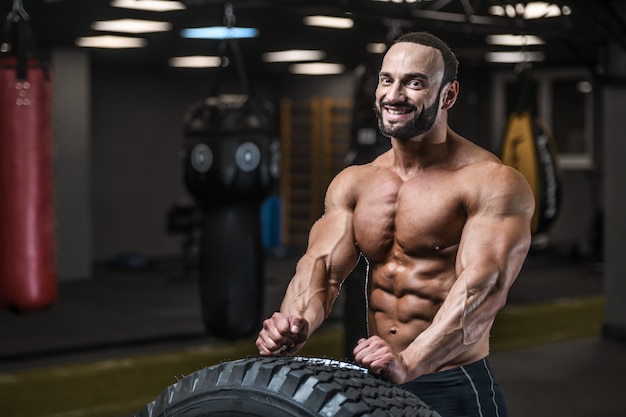 Hommes athlétiques bodybuilder forts brutaux pompant les muscles avec des haltères