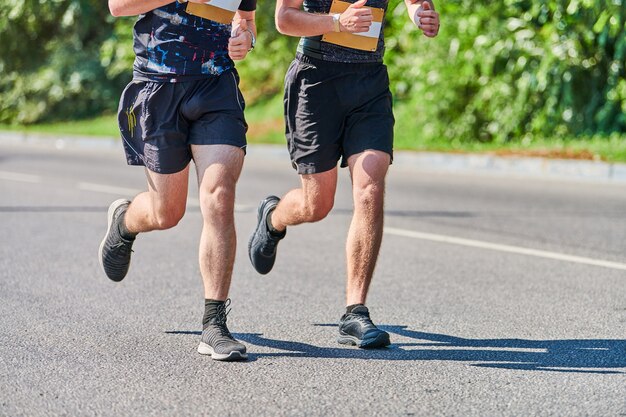 Hommes athlétiques jogging en tenue de sport sur route de la ville