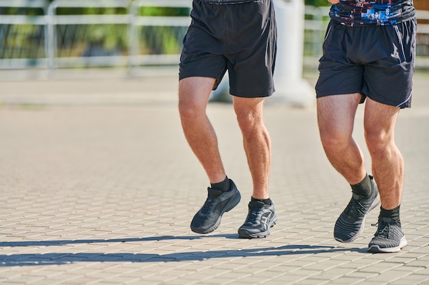 Hommes athlétiques jogging en tenue de sport sur route de la ville