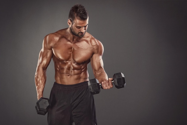 Les hommes athlétiques musclés s'exercent avec des haltères