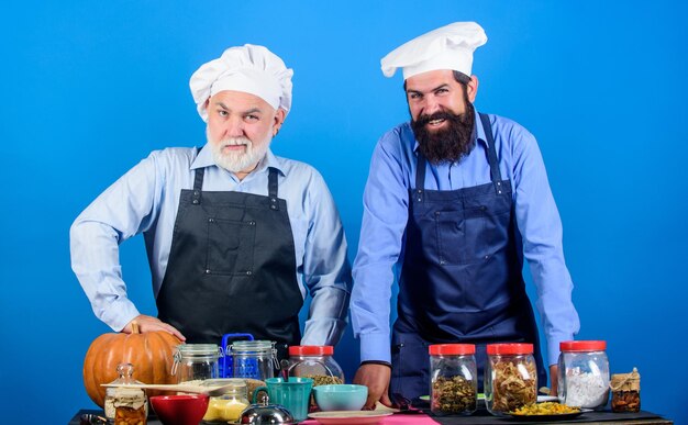 Hommes barbus seniors matures dans la cuisine Recette de citrouille d'Halloween Chef hommes cuisine hommes gais préparent des céréales alimentaires et assaisonnement restaurant professionnel cuisinier Cuisine saine Photo de nourriture