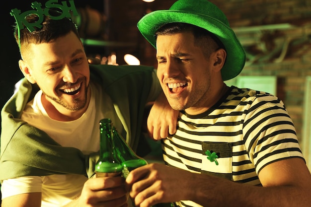 Photo hommes avec de la bière célébrant le jour de la st patrick dans un pub