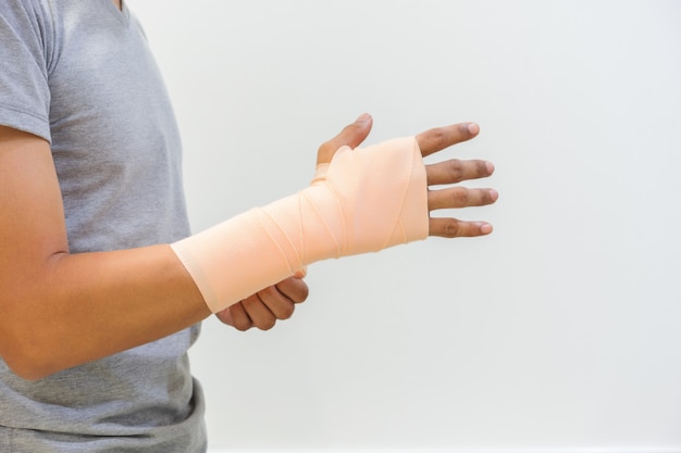 Photo les hommes blessés par une inflammation du tendon en utilisant un bandage élastique. pour aider à réduire les blessures et réduire l'enflure. concept médical et des soins de santé