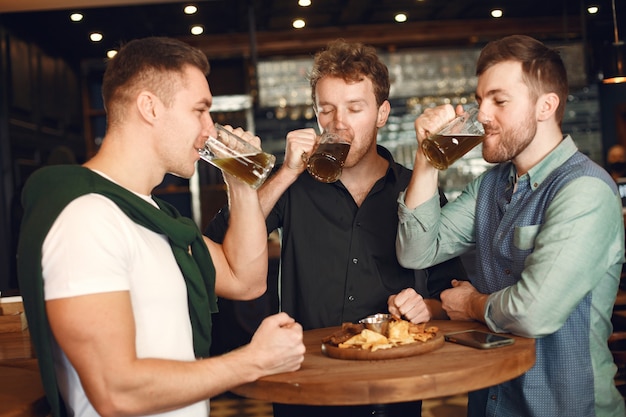 Les hommes buvant des bières dans un pub.