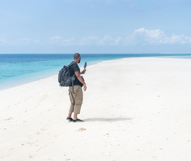 Hommes avec caméra de smartphone filmant une belle plage tropicale