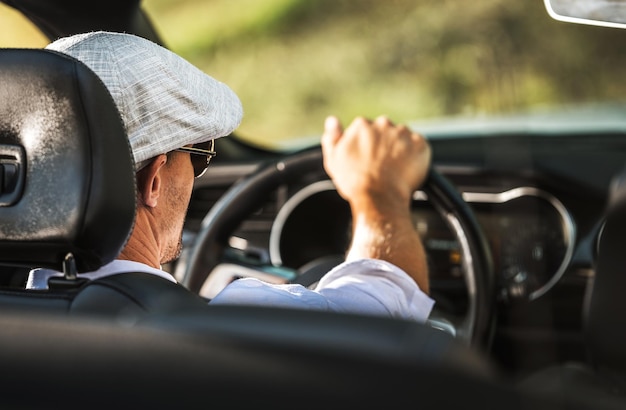 Des hommes caucasiens d'une trentaine d'années conduisent une voiture décapotable moderne pendant une chaude journée d'été