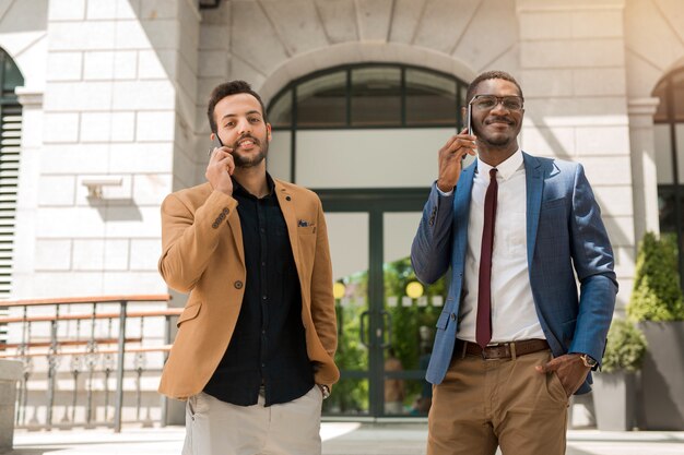 des hommes en costume parlent au téléphone