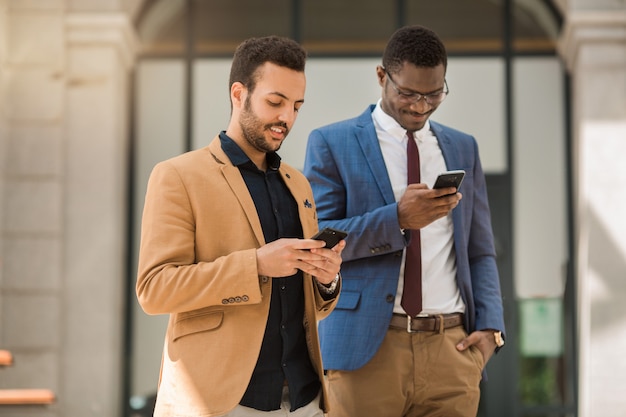 hommes en costume avec des téléphones à la main