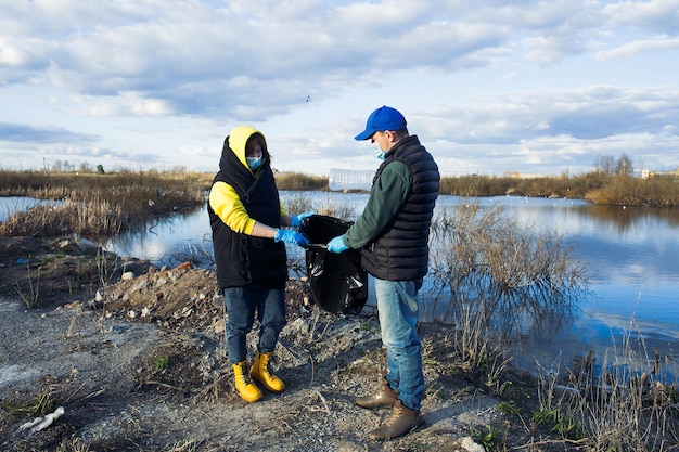 Photo des hommes debout au bord du lac contre le ciel pendant l'hiver