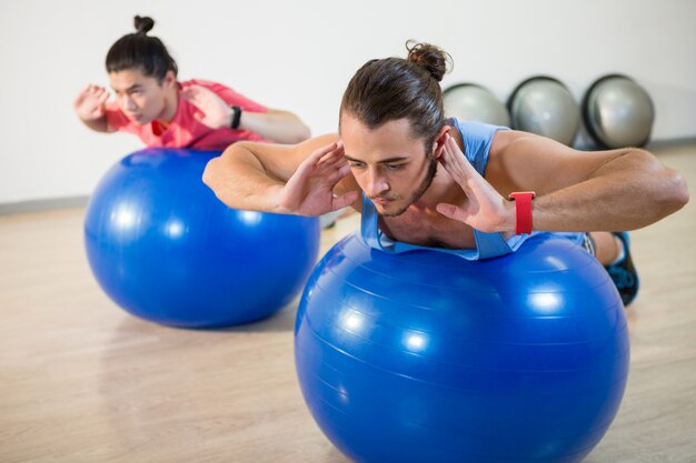 Hommes exerçant sur ballon d'exercice