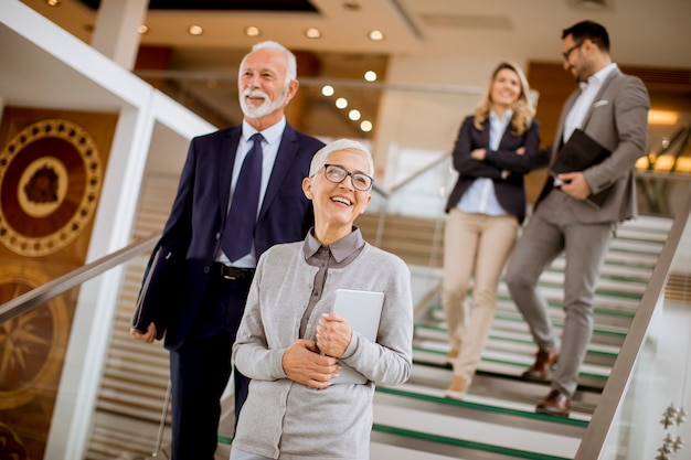 Hommes et femmes d&#39;affaires marchant et prenant des escaliers dans un immeuble de bureaux