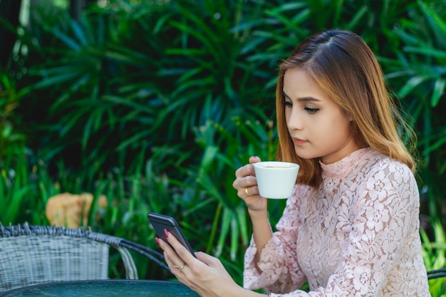 Les hommes et les femmes d’affaires utilisent un téléphone intelligent et mobile pour la communication et vérifient les gens d’affaires au fond de leur bureau