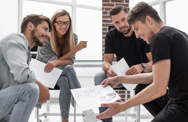 Hommes et femmes assis ensemble dans un bureau moderne pour discuter d'un projet