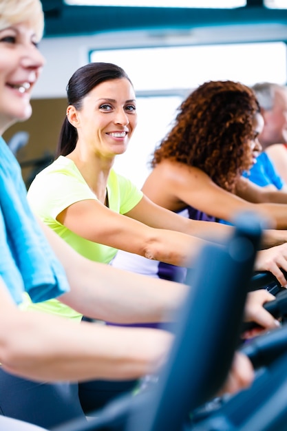 Hommes et femmes faisant du fitness spinning pour le sport