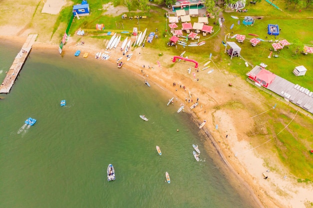 Des hommes forts flottant sur des planches de SUP dans une magnifique baie par une journée ensoleillée Vue aérienne des hommes traversant la baie à l'aide du paddleboard Compétitions de sports nautiques