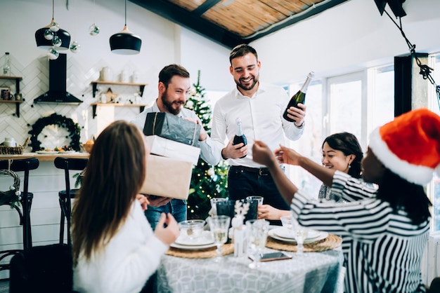 Hommes gais portant des bouteilles de champagne à table