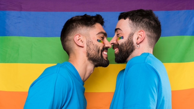 Les hommes homosexuels face à face sur le drapeau arc-en-ciel LGBT