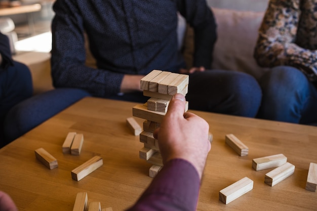 Photo hommes jouant à un jeu avec des blocs en bois