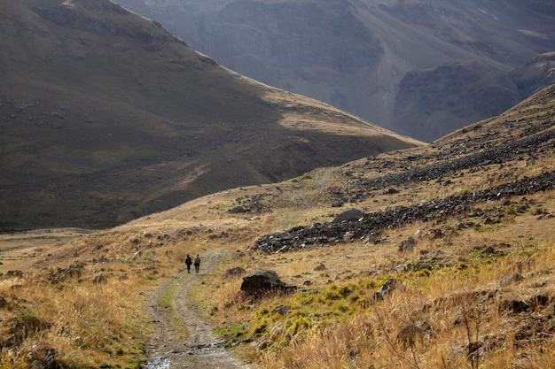 Les hommes marchent dans les montagnes le long d'un chemin de terre